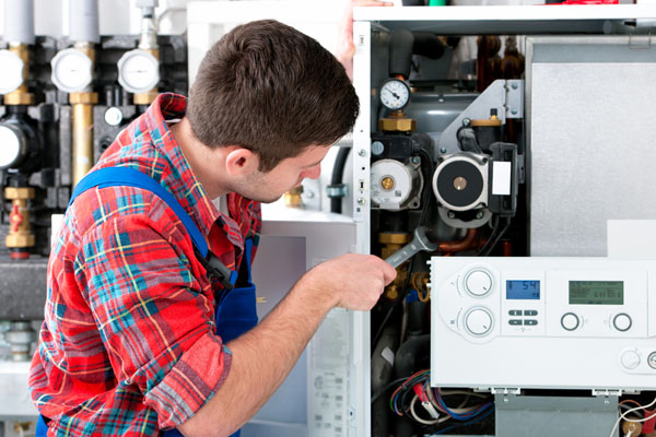 Heating technician repairing boiler controls in Vacaville