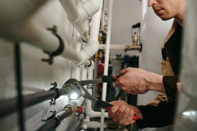 Technician inspecting commercial plumbing pipes in Vacaville